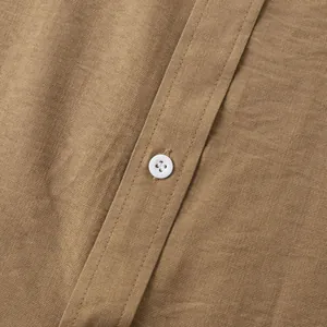 Gedetailleerde macro-opname van de textuur van een kaki linnen hemd met witte knoop.