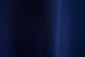 High-resolution macro shot of the navy blue textured crepe fabric for men's casual shirts