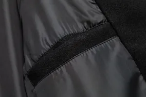 Detalle del forro interior negro y del tejido de un abrigo de lana para hombre