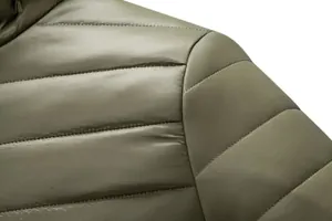 Macro detail showing the quilted shoulder stitching and fabric texture of a green puffer jacket