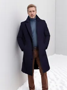 Full view of men's navy blue wool coat on model against a minimalist snowy wall