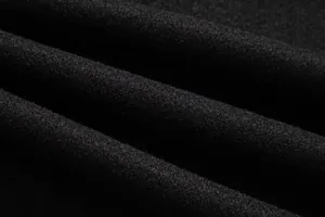 Vista macro que muestra la textura de tela de lana negra suave y densa del abrigo
