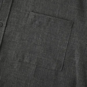 Detailed macro close-up showing dark grey cotton linen fabric texture and chest pocket