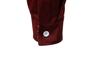Detailed view of a burgundy long-sleeve men's shirt cuff with a premium white button
