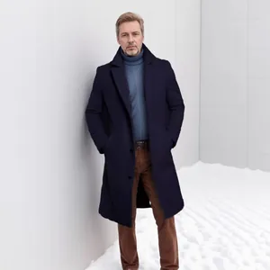 Élégant manteau en laine bleu marine pour homme dans un décor hivernal minimaliste