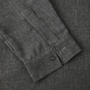 Close-up detail view of the grey cotton linen shirt sleeve cuff with button texture