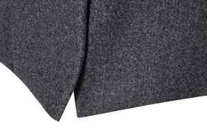Close-up of high-quality dark grey woolen fabric hem on a men's long coat