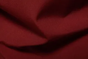 High-quality detailed texture of the dark red burgundy fabric for a men's casual shirt