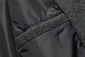 Primer plano del forro suave y las costuras de lana gris en un abrigo de hombre