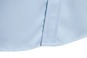Close-up detail of neat hem stitching on a light blue men's casual long-sleeve shirt