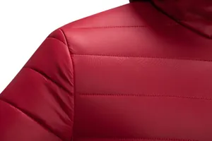 Close-up macro shot of the red quilted fabric and fine stitching on a men's winter jacket