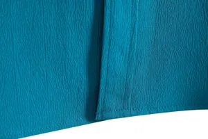 Close-up of teal men's casual shirt with premium crepe fabric texture and stitching.