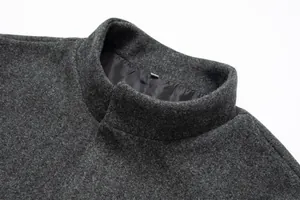 Primer plano detallado del cuello alto de un abrigo de lana para hombre gris oscuro.