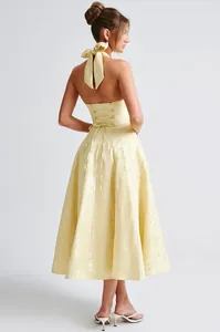 Back view of yellow halter jacquard midi dress with corset lace-up and bow detail