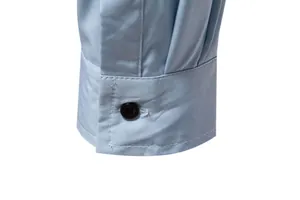 Close-up of a light blue long-sleeve shirt cuff with black button and white stitching