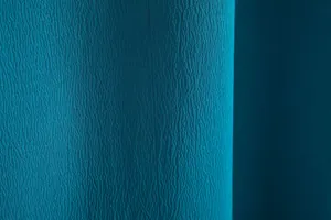 Macro detail of teal textured fabric for men's casual shirt with fine crinkle finish