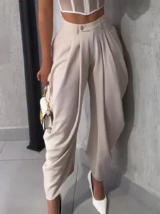 Detailed view of high waisted beige harem trousers with draped pleated design