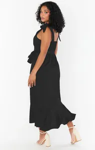 Elegant black sleeveless midi dress with ruffle hem and bow shoulder detail