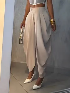 Detail of high-waisted beige tulip pants with elegant pleats and tapered ankle fit