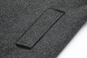 Primer plano del bolsillo lateral de un abrigo de lana gris con textura de tela de calidad