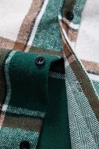 Primer plano de la tela de franela a cuadros verde y marrón con un botón negro