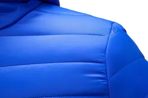 Close-up detail of blue padded winter jacket showing stitching and fabric texture