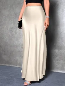 Close-up of elegant champagne satin maxi skirt with smooth silk-like texture and drape.
