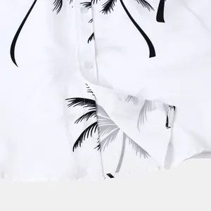 Détail du motif de palmier noir sur une chemise de plage hawaïenne blanche pour homme