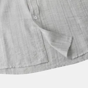 Close-up van lichtgrijze linnen textuur en knoopsluiting op een herenshirt