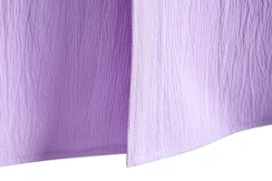 Macro detail of purple textured fabric showing neat stitching on a men's casual shirt hem