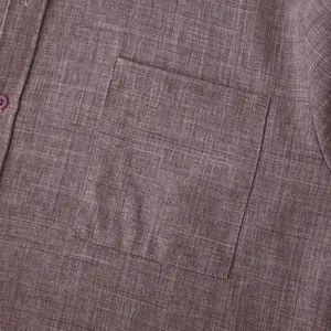 Macro detail of a classic chest pocket on a maroon linen-blend men's casual shirt.
