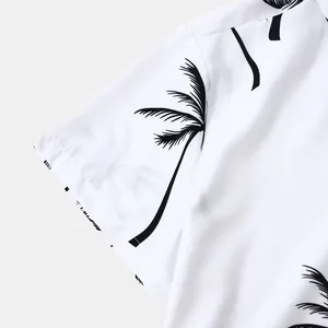 Détail de l'imprimé palmier noir sur la manche d'une chemise hawaïenne blanche.