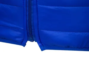 Close-up detail of zipper and hem on a men's lightweight blue quilted winter jacket.