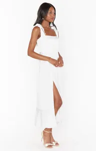 Elegant white French style midi dress featuring a side slit and ruffled shoulder straps detail