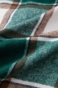 Primer plano macro de tela de camisa a cuadros verde y marrón con textura de espiga.