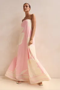 Elegant pink and cream floral strapless maxi dress with a flowing silhouette for summer.