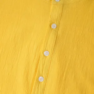Macro view of bright yellow cotton linen shirt showing fabric texture and buttons