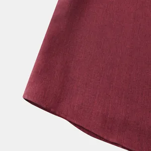Primer plano de la textura de la tela y el dobladillo curvado de una camisa burdeos para hombre
