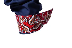 Close-up detail of a navy blue men's shirt cuff featuring a vibrant red paisley pattern lining