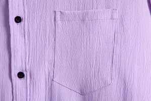 Close-up detail of purple textured fabric and chest pocket on a men's casual shirt