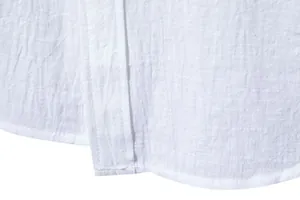 Close-up macro view of the hem and textured cotton linen fabric of a white men's shirt.