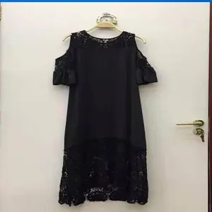 Dettaglio dell'abito nero con spalle scoperte, pizzo raffinato e maniche con volant.