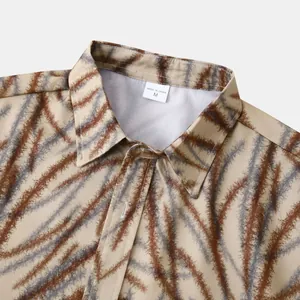 Gros plan du col d'une chemise hawaïenne pour homme avec motif abstrait marron et gris.