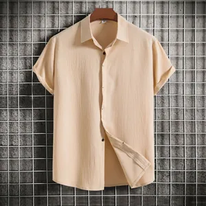Detail of beige textured short-sleeve shirt with button-down collar and dark buttons