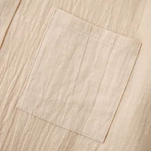 Κοντινό πλάνο τσέπης στο στήθος μπεζ βαμβακερού λινού πουκάμισου με φυσική υφή υφάσματος