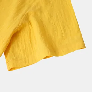 Close-up detail of yellow cotton linen fabric and sleeve cuff on men's summer casual shirt.