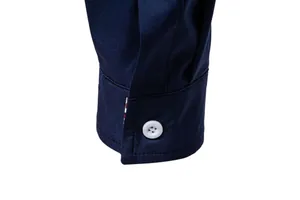Detailed close-up showing the navy blue fabric and white button of a men's shirt cuff