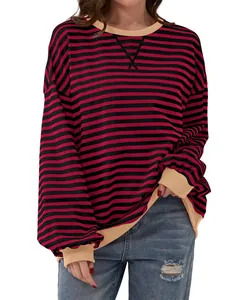 Macro view of red and black striped long sleeve sweatshirt featuring beige ribbed cuffs.