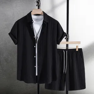 Detailed view of a textured black men's summer shirt and shorts set on clothing hangers