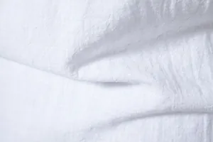 Macro view of white cotton linen fabric texture for men's long sleeve shirt product.